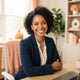 A professional portrait of a smiling woman in a bright, modern office setting, representing a satisfied customer.